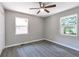 Bedroom features new gray floors, a ceiling fan, and two windows at 732 Quaker Sw St, Atlanta, GA 30315