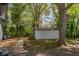 Backyard view of a storage shed surrounded by lush green trees, with a quaint walking path at 1956 Washington Rd, East Point, GA 30344