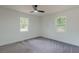 Spacious bedroom featuring two windows, gray carpet, and neutral-colored walls at 1956 Washington Rd, East Point, GA 30344