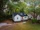 Charming home featuring a bright red front door, manicured lawn, and mature trees at 1956 Washington Rd, East Point, GA 30344