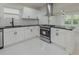 Newly renovated kitchen featuring stainless appliances, white cabinets, and an island cooktop at 1956 Washington Rd, East Point, GA 30344