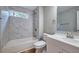 Bright bathroom featuring a white sink, toilet, and tub with marble-style tiling at 3650 Clovis Nw Ct, Atlanta, GA 30331