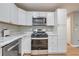 Kitchen boasts stainless steel appliances, white cabinets, and bright, airy design at 3650 Clovis Nw Ct, Atlanta, GA 30331