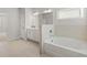 Bright bathroom featuring a soaking tub, white cabinetry, and tiled floors at 3681 Deaton Trl, Buford, GA 30519