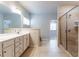 Bright bathroom featuring a double vanity, tiled shower, and neutral decor at 3681 Deaton Trl, Buford, GA 30519