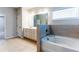 Modern bathroom features a soaking tub, large mirror, and tile flooring at 3681 Deaton Trl, Buford, GA 30519