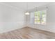 Bright dining room with wood floors, neutral paint, large window, and elegant chandelier at 3681 Deaton Trl, Buford, GA 30519