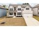 Charming two-story white brick home with a well-manicured front lawn and attached two-car garage at 3681 Deaton Trl, Buford, GA 30519