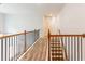 Bright upstairs hallway with wood floors, black railing, and stairs leading to the lower level at 3681 Deaton Trl, Buford, GA 30519