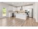 Bright kitchen with white cabinetry, stainless steel appliances, and an island, complemented by hardwood floors and natural light at 3681 Deaton Trl, Buford, GA 30519