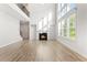 Sunlit living room with fireplace, hardwood floors, and large windows, complemented by a modern staircase and open design at 3681 Deaton Trl, Buford, GA 30519