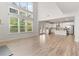 Open-concept living room featuring hardwood floors, large windows and an open view to the modern kitchen at 3681 Deaton Trl, Buford, GA 30519
