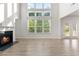 Bright living room featuring large windows, fireplace, and hardwood floors, creating a warm and inviting atmosphere at 3681 Deaton Trl, Buford, GA 30519