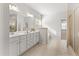 Luxurious bathroom with double vanity, tile floors, large mirror, glass shower, and soaking tub at 3681 Deaton Trl, Buford, GA 30519