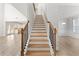 Elegant staircase featuring hardwood treads, black iron balusters, and a natural wood handrail at 3681 Deaton Trl, Buford, GA 30519