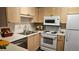 Functional kitchen with wooden cabinets, white appliances, and ample counter space at 434 Bentley Place, Tucker, GA 30084