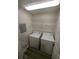 Functional laundry room with washer, dryer, and wire shelving at 434 Bentley Place, Tucker, GA 30084