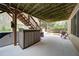 Outdoor patio area with a covered pergola, hot tub, and staircase access to the deck above at 4981 Millwood Dr, Canton, GA 30114