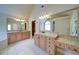Dual vanities featuring granite countertops, under-mount sink, large mirror with decorative lighting, and white tile floors at 4981 Millwood Dr, Canton, GA 30114
