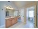 Bathroom vanity featuring granite countertops, under-mount sink, large mirror with decorative lighting, and white tile floors at 4981 Millwood Dr, Canton, GA 30114