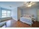 Bedroom with ceiling fan, window seat, and wooden floors, painted in a tranquil blue at 4981 Millwood Dr, Canton, GA 30114