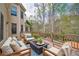 Spacious deck with cozy seating, a fire pit coffee table, and views of the wooded backyard at 4981 Millwood Dr, Canton, GA 30114