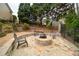 Backyard stone fire pit and gravel-covered area with chairs surrounded by lush landscaping at 4981 Millwood Dr, Canton, GA 30114