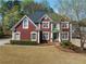 Charming red brick two-story home featuring a well-manicured lawn and mature trees at 2924 Meadow Church Rd, Suwanee, GA 30024