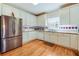 Bright kitchen with white cabinets, stainless steel fridge, tile backsplash and wooden floor at 2924 Meadow Church Rd, Suwanee, GA 30024