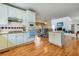 Open-concept kitchen with white cabinetry, stainless steel appliances, tile backsplash and connecting living area at 2924 Meadow Church Rd, Suwanee, GA 30024