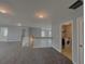 Open loft area with neutral walls, plush carpet, and convenient laundry room access at 3354 Preserve Run Trl, Loganville, GA 30052