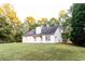 Backyard of a white house with a chimney, windows, grass, and trees at 355 Freeman Dr, Covington, GA 30016
