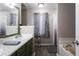 Well-lit bathroom with dual sinks, modern fixtures, and a combined bathtub and shower at 355 Freeman Dr, Covington, GA 30016
