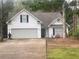 Charming home with a two-car garage, black shutters, and mature trees at 355 Freeman Dr, Covington, GA 30016