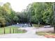 Well-maintained tennis court surrounded by lush greenery in a wooded area at 355 Freeman Dr, Covington, GA 30016