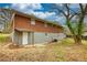 Backyard view of a brick home featuring a walkout basement and mature trees at 7535 Asbury Dr, Riverdale, GA 30274