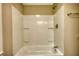 Full bathroom features a white tub with shower, white walls and chrome fixtures at 7535 Asbury Dr, Riverdale, GA 30274