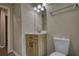 Bathroom featuring a wood vanity, white sink, modern fixtures, white toilet and a linen closet at 7535 Asbury Dr, Riverdale, GA 30274