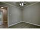 Empty bedroom featuring a ceiling fan, window, light-colored walls, and light wood plank flooring at 7535 Asbury Dr, Riverdale, GA 30274