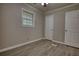 Empty bedroom features a window, light-colored walls, and light wood plank flooring at 7535 Asbury Dr, Riverdale, GA 30274