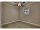 Empty bedroom with ceiling fan, window, light-colored walls, and light wood plank flooring at 7535 Asbury Dr, Riverdale, GA 30274