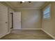Bedroom features modern flooring, neutral paint, a window, and three doors at 7535 Asbury Dr, Riverdale, GA 30274