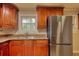 Updated kitchen showcases stainless steel appliances, granite countertops and cherry wood cabinetry and recessed lighting at 7535 Asbury Dr, Riverdale, GA 30274