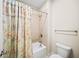 Well-lit bathroom with a shower-tub combination and a floral-patterned shower curtain at 930 Crestview Dr, Johns Creek, GA 30024