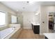 Luxurious bathroom featuring a soaking tub, glass enclosed shower and access to a walk-in closet at 930 Crestview Dr, Johns Creek, GA 30024