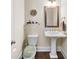 Charming powder room features a pedestal sink, decorative mirror, and stylish wall decor at 930 Crestview Dr, Johns Creek, GA 30024