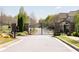 Secured community entrance with black metal gates, stone pillars, and well-maintained landscaping at 930 Crestview Dr, Johns Creek, GA 30024