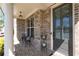 Charming brick-paved front porch featuring elegant columns and a cozy seating area by the front door at 930 Crestview Dr, Johns Creek, GA 30024