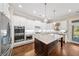 Bright kitchen with granite island, stainless appliances, white cabinets, and hardwood floors at 930 Crestview Dr, Johns Creek, GA 30024