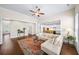 Spacious living room showcasing hardwood floors, ample seating, and an open layout leading to the kitchen at 930 Crestview Dr, Johns Creek, GA 30024